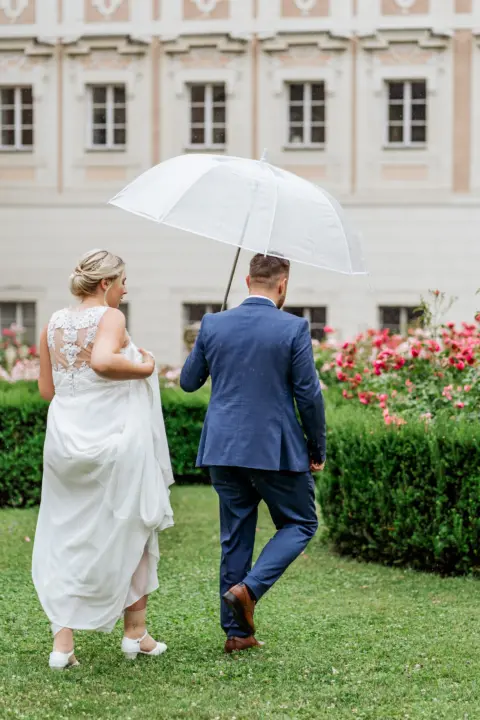Aina und Lukas spazieren mit Regenschirm durch den Schlossgarten im Schloss Lamberg in Steyr - Martin Schinnerl Fotografie