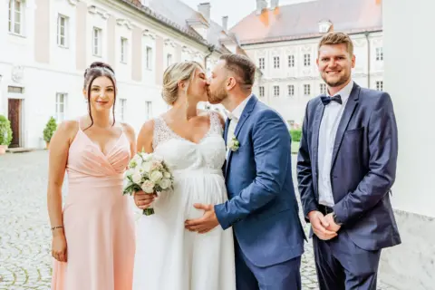 Alina und Lukas küssen sich nach der Trauung im Beisein ihrer Trauzeugen - Martin Schinnerl Fotografie