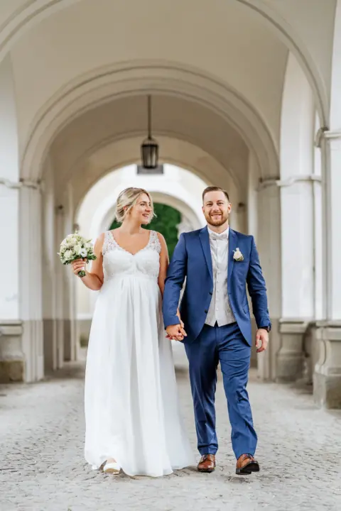 Alina und Lukas mit Brautstrauß händchenhaltend im Schloss Lamberg - Martin Schinnerl Fotografie