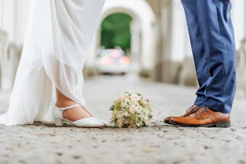 Alinas und Lukas Füße mit Brautstrauß im Schloss Lamberg - Martin Schinnerl Fotografie