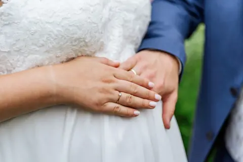 Alinas und Lukas Hände mit Trauringen am Babybauch von Alina - Martin Schinnerl Fotografie