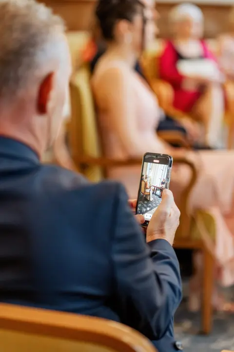 Lukas Papa filmt mit dem Smartphone die standesamtliche Trauung - Martin Schinnerl Fotografie