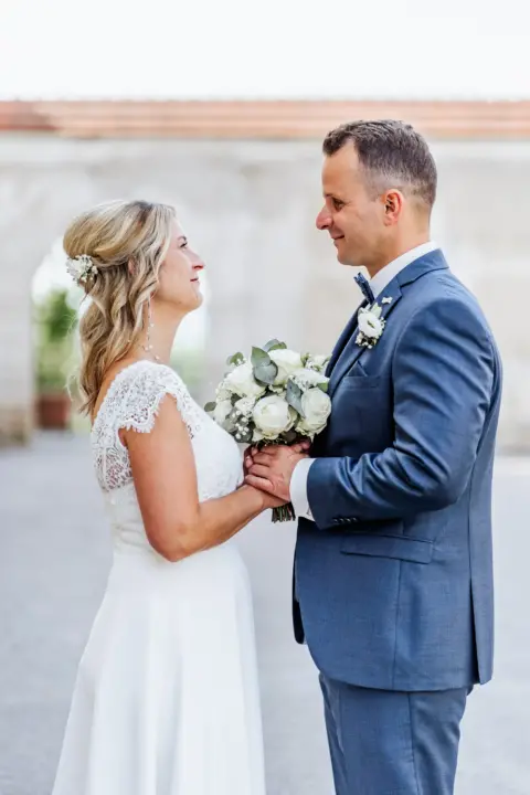 Petra und Gerhard sehen sich an mit Brautstrauß in der Hand - Martin Schinnerl Fotografie