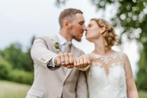 Klara und Michael strecken ihre Fäuste mit Ehering der Kamera entgegen - Martin Schinnerl Fotografie