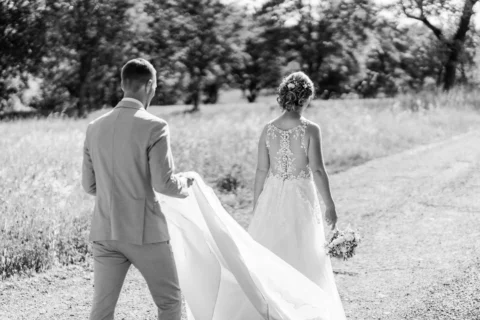 Michael hilft Klara beim Tragen der Schleppe ihres Hochzeitskleides - Martin Schinnerl Fotografie